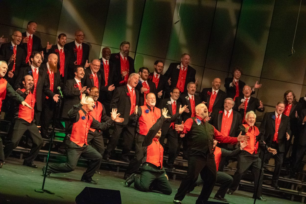 The Masters of Harmony in red vests, the whole chorus singing out to the audience at the 2024 Spring Show